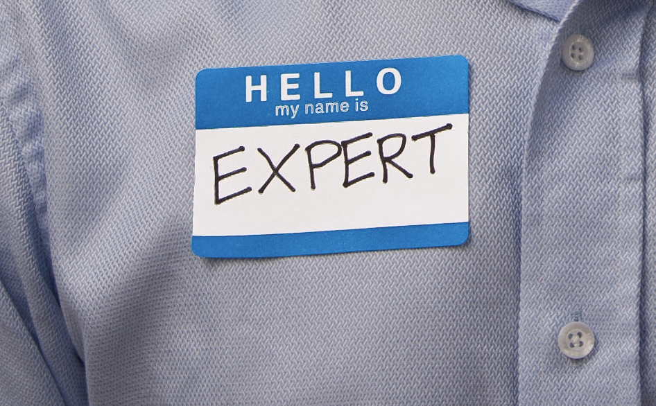 "Hello my name is expert" name tag on business shirt