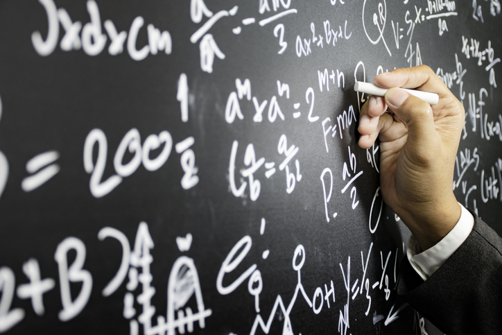 Hand writing complicated equations on a chalkboard